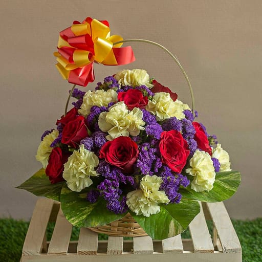 Basket of red roses, carnations and Purple Statices