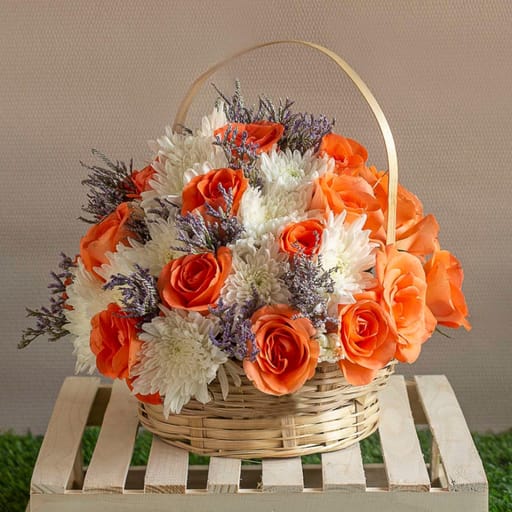 Arrangement Of White Chrysanthemums And Orange Roses In A Baskets