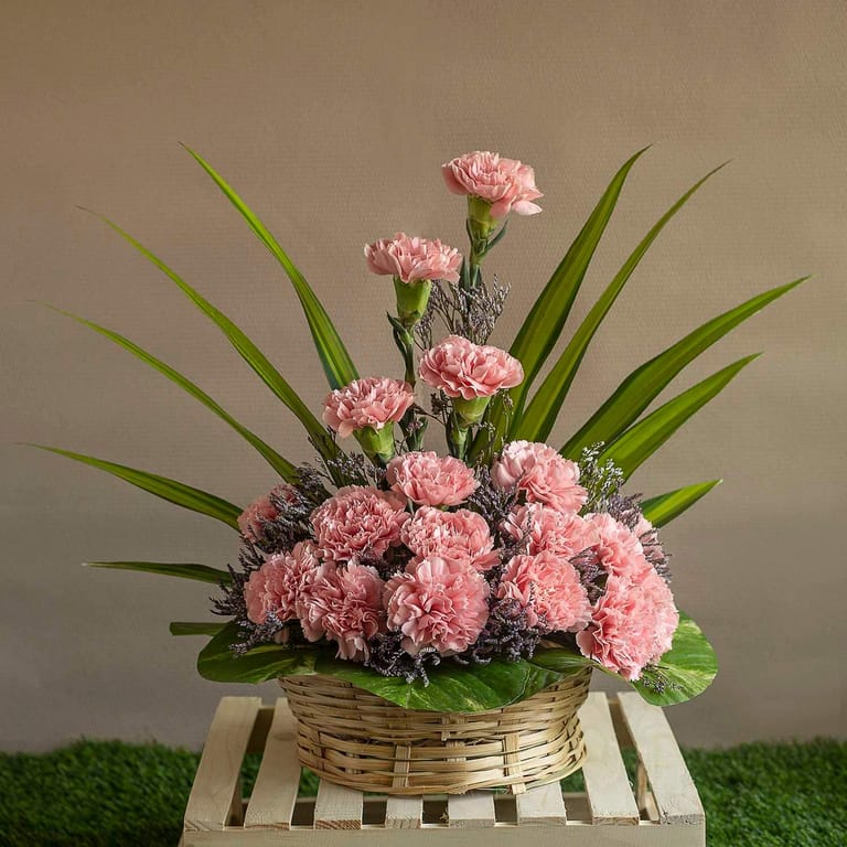 Arrangement Of Pink Carnations And Leaves In A Basket - Image 1
