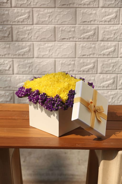 Yellow chrysanthemum and blue statice in a box